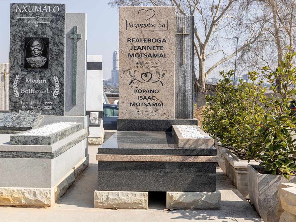 Restoration expert re-lettering an old granite tombstone in Johannesburg
