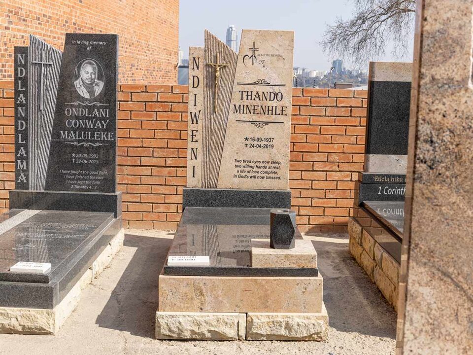 Close-up of angel and cross carvings on a granite tombstone in South Africa